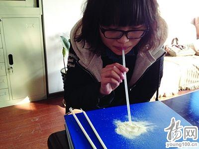 A girl sucks the powdery snack through a straw.