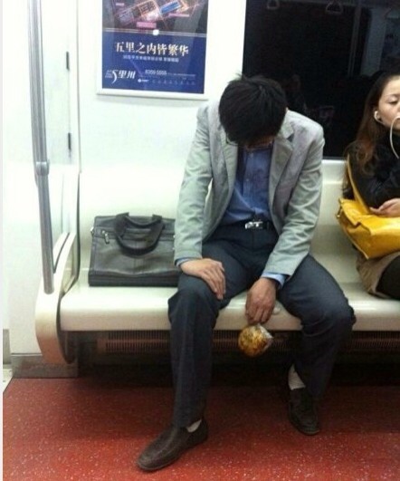 A white collar dozes off on subway, with snack in hand. (Photo source: screen shot from Weibo)