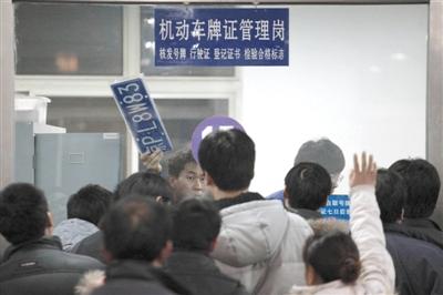 A staffer is delivering car plates to citizens in a office hall. (Photo source: the Beijing News)