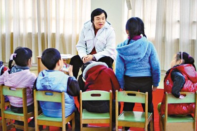 A teacher teaches children to speak Shanghai dialect at a local kindergarten. (Photo source: People's Daily)