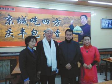 Wu Songjin (2nd L), takes a photo with the song's singer and shop staffers in the Beijing bun shop. 