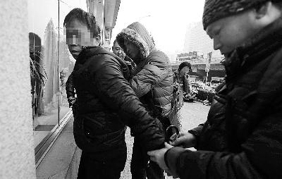 Plainclothes police officers capture a hospital scalper at Beijing Children's Hospital. (Photo source: Legal Evening News)