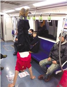 Zhang Shangwu, a former star gymnast, performs handstands on Beijing subway.