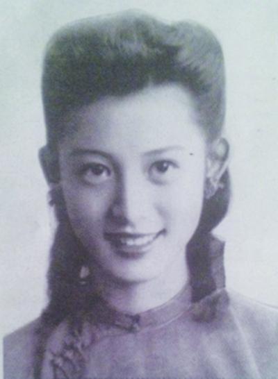 The woman in a black and white photo has a sweet smile and big eyes.