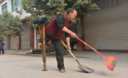 Zhang Changjiang, being crowned as the the toughest cleaner in China by netizens, is cleaning street. ( Photo: West China City Daily)