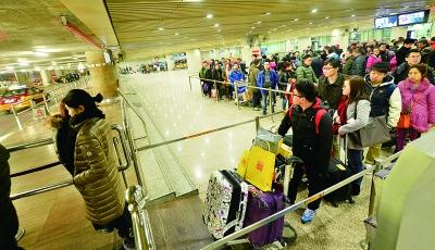 Passengers stands in long lines waiting for taxis on the last day of the Spring Festival holiday.