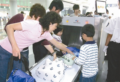 Passengers take bag-scanning in a subway station in Beijing. (Photo source: China.org.cn)