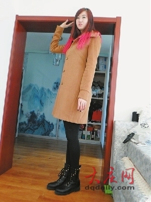 Liang Tianyun, a two-meter-tall girl, is standing in front of a regular-sized door. (Photo source: dqdaily.com)