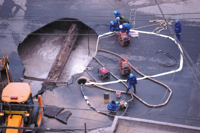 A road collapse occurs near a road crossing at Chaoyang district of Beijing on the afternoon of Sunday. The hole, with a diameter of about five meters and depth of five meters, interrupted traffic in the neighborhood. (Photo source: Beijing Times)