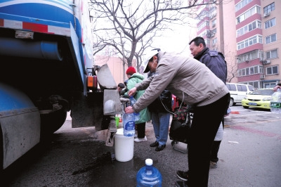 Residents are taking water from an emergency water tender dispatched by the Beijing Waterworks Group to the accident spot. (Photo source: Beijing Times)