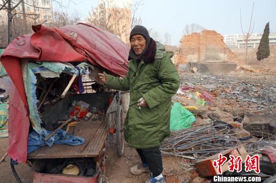 A 70-year-old man who lives in a cemetery in Henan province ans his tricycle. [Photo: Zhou Xiaoyun]