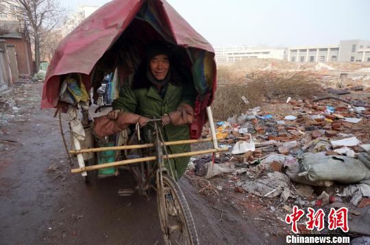 A 70-year-old man who lives in a cemetery in Henan province ans his tricycle. [Photo: Zhou Xiaoyun]