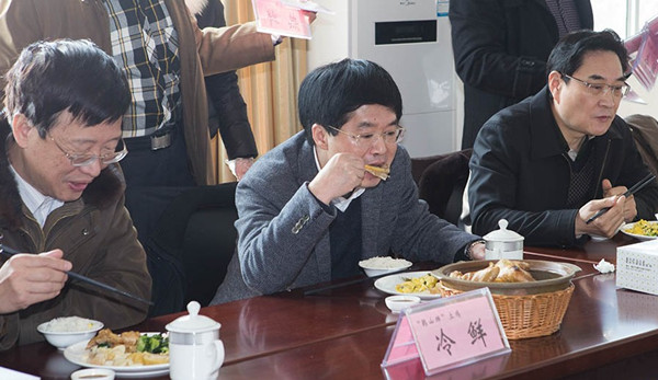 Zheng Jiwei (R), vice governor of Zhejiang province is eating dishes cooked with fresh chicken. (Photo source: China.com.cn)