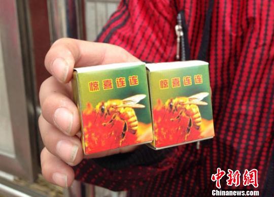A students showcases the pacakages of bee pupae toys. (Photo source: chinanews.com)
