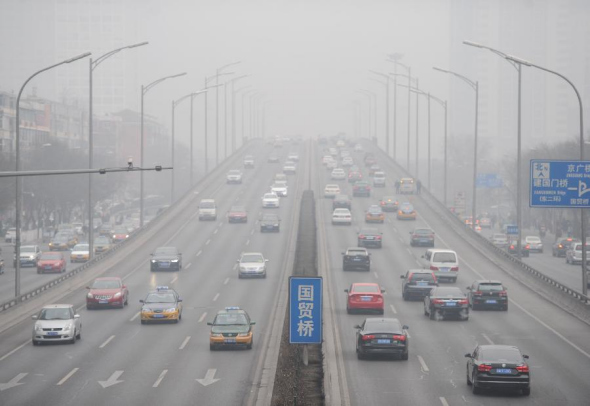 Vehicles run on smog-shrouded road in Beijing, capital of China, Feb 20, 2014. Beijing on Thursday issued a yellow alert for air pollution in the next three days. (Xinhua/Luo Xiaoguang)