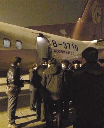 Maintenance personnel are checking a Xinzhou-60 plane after it hovered above Shenyang Taoxian International Airport for three hours on Tuesday night due to a potential landing gear problem. (Photo source: bjnews.com.cn)