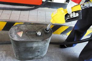 A staffer at a petrol station fulfills a container. 
