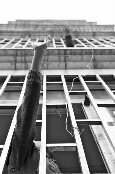 The two boys living on different floors wave to each other arcoss the windows. (Photo source: dahe.cn)