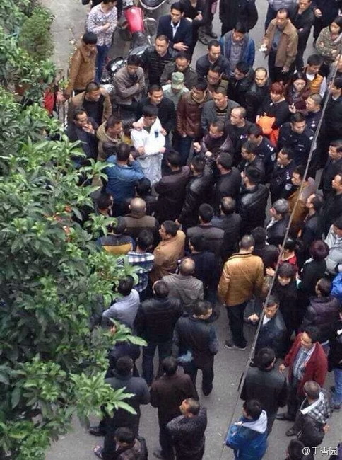 The doctor in white is forced by dozens of people to march in shame around Chaozhou Central Hospital. (Photo source: screen shot from Sina Weibo)