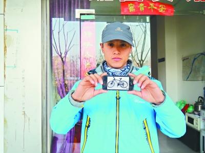 Zhang Youzhi displays a photo of his lost bike at the hotel in Wuhan. (Photo source: Changjiang Daily)