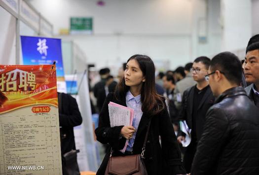 A job seeker looks at information during a job fair in Hangzhou, capital of east China's Zhejiang province, March 12, 2014. Over 7.27 million students are estimated to graduate in this year and enter job market. (Photo source: Xinhua)