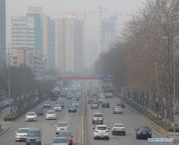 Motorcars run on a road amid smog in Shijiazhuang, capital of north China's Hebei province, March 10, 2014. Smog hit 11 cities in the province and lingered for three days since March 8. The local environmental bureau has issued yellow alert for smog for three days in a row. (Xinhua/Mo Yu)