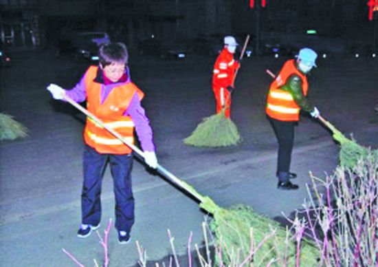 An official in Fushun, Liaoning province, was accused of making a show of doing voluntary work after she was exposed of cleaning streets accompanied by professional photographers recording her activities.(Photo source: Southern Metropolis Daily)