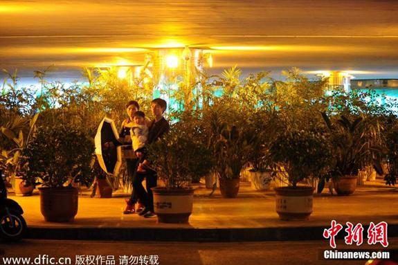 Passersby walk across the potted plants placed at the ring passageway under Guibei overpass in Kunming, Yunan province. (Photo source: chinanews.com)