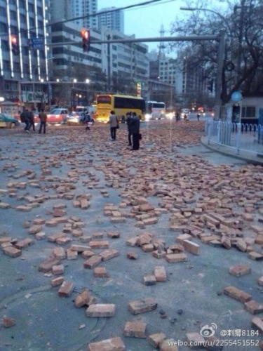 Photo posted online by a netizen shows bricks scattered on roads near the railway station in Lanzhou, Gansu province.(Photo source: Sina Weibo)