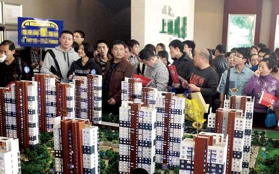 Numbers of house buyers are surrounding house models displayed at a house sales hall in Baoding, Hebei province. (Photo source: the Legal Evening News)