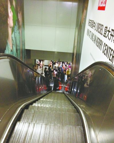 An escalator at Shanghai's Jing��an Temple station traveling upward on Wednesday suddenly reversed, causing passengers to fall. (Photo/Xinhua)