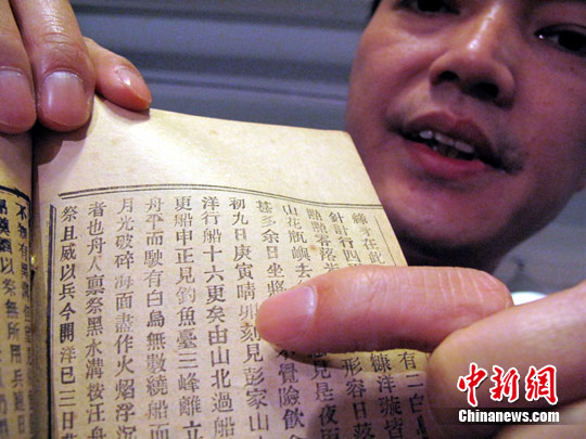 The photo taken in 2011 shows a man displaying one page of Mission to Ryukyu Islands, which contains content that Qing's ambassadors have passed by Diaoyu Islands. (Photo source: CNS)