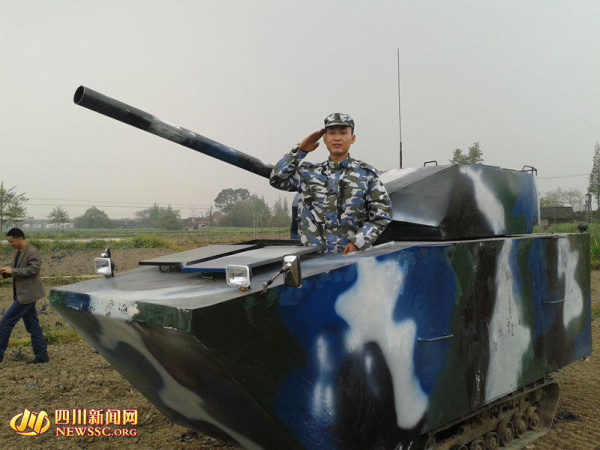 Jian Lin, in uniform, poses for a picture with the tank he makes. (Photo source: newsssc.org) 