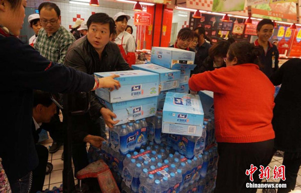 People snap up bottled water at a supermarket in Lanzhou, Gansu province, April 11, 2014. Tap water in downtown Lanzhou has been found to contain excessive levels of benzene. [Photo / Chinanews.com]