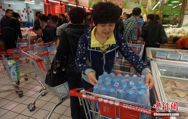People snap up bottled water at a supermarket in Lanzhou, Gansu province, April 11, 2014. Tap water in downtown Lanzhou has been found to contain excessive levels of benzene. [Photo / Chinanews.com]