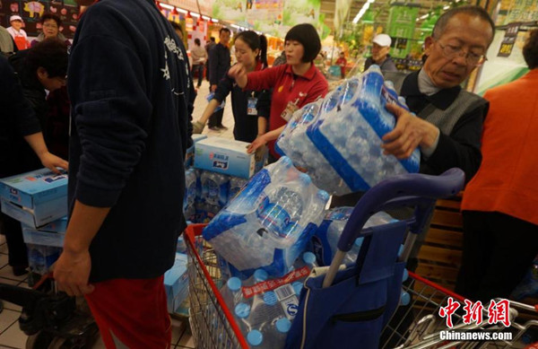 People snap up bottled water at a supermarket in Lanzhou, Gansu province, April 11, 2014. Tap water in downtown Lanzhou has been found to contain excessive levels of benzene. [Photo / Chinanews.com]