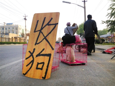 Dealers are seen buying and selling dogs by a road in Beijing. [Photo / The Beijing News]