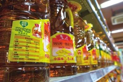 Peanut oils are displayed on a shelf in a market for sale. (Photo source: the Beijing Times)