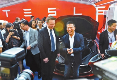 A car buyer receives key from Tesla CEO Elon Musk (Central, Left). [Photo/Beijing Youth Daily]