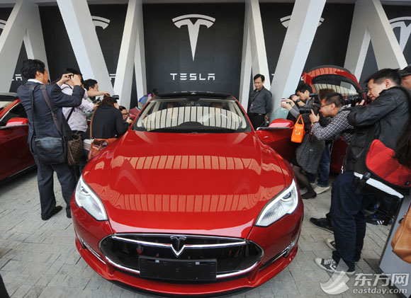 Crowds take photos of a Tesla model at the handover ceremony held in Shanghai on Wednesday. (Photo source: eastday.com)