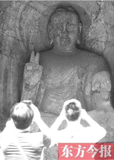 Two tourists take photos of the Buddha statue making V sign. (Photo source: the Orient Today)