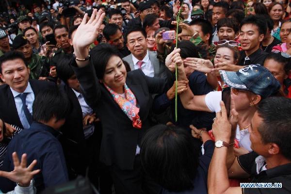 Thai caretaker Prime Minister Yingluck Shinawatra(C) greets supporters after a press conference in Bangkok, Thailand, May 7, 2014. (Photo sourceXinhua)