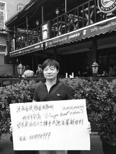 Chai Bobo holds a sign saying Village Head Invites Investment. [Photo: dahe.cn]