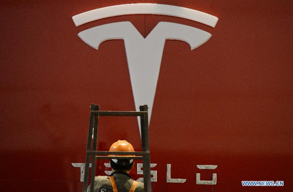 A worker installs the logo of Tesla during the 2nd China Shanghai International Technology Fair (CSITF) in east China's Shanghai, April 24, 2014. Tesla Motors is an American company which designs and manufactures electric vehicles. (Xinhua/Lai Xinlin)