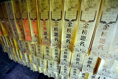 Pieces of paper on a wall of the temple with words high scores in the exam.[Photo: West China City Daily]