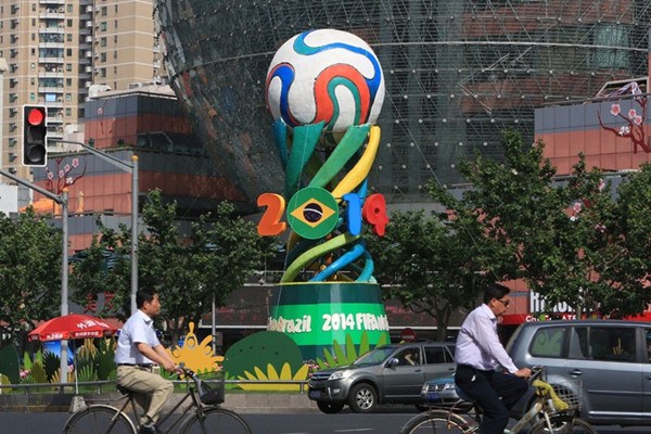 An installation featuring a giant representation of the 2014 World Cup stands at a junction in Shanghai's Xujiahui shopping area. (Photo/Shanghai Daily)