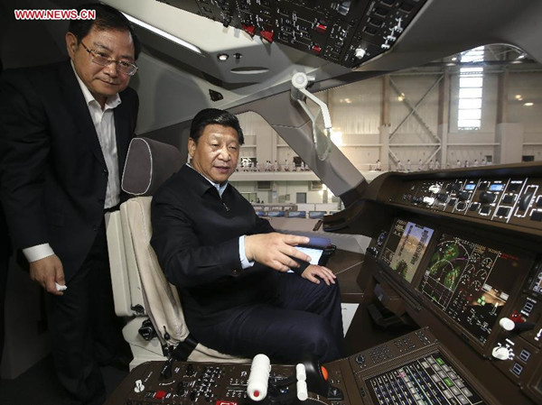 Chinese President Xi Jinping (R) watches in the pilothouse of C919 passenger jet model at the design and research center of Commercial Aircraft Corporation of China (COMAC) during his inspection in Shanghai on May 23, 2014. (Photo source: Xinhua)