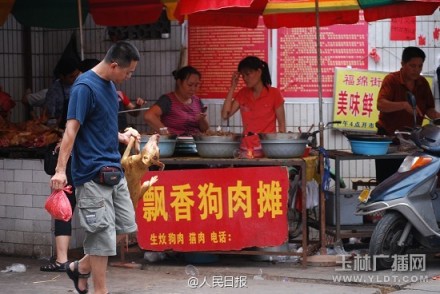 The undated photo shows a man holds a slaughtered dog with one hand in Yulin, Guangxi. [Photo: yldt.com]