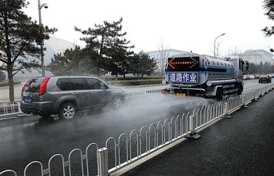 The photo taken on February 21, show a road sprinkler is working along the Chang'an Avenue. [Photo/the Beijing News]
