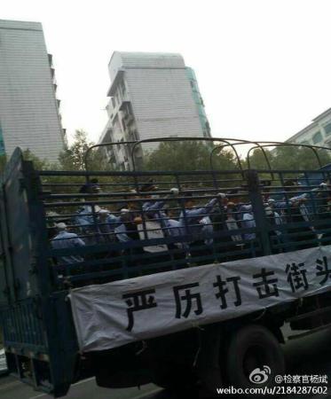 Suspects are standing behind iron bars on moving trucks. [Photo: Sina Weibo]